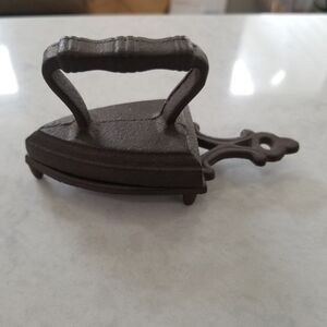 Vintage miniature cast iron toy sad iron with a trivet, likely from the 1940s.